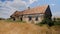 Old dilapidated rural house with a red-tiled roof