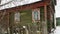 The old, dilapidated village house with exterior windows in winter.