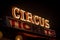 Old dimly lit circus sign with light bulbs in the dark over a ticket stand. Typical view of an entrance to a circus. Concept of