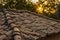 Old dirty brown shingle house soft focus roof outdoor in evening sunset time with sun rays background, rural environment