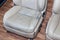 Old dirty car seat beige color of perforated leather with cracks and scuffs in the workshop for repair and restoration of vehicle