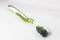 An old and dirty green toothbrush used to clean dirty surfaces. Reused and repurposed as general purpose brush. On a plain