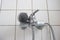 Old dirty limescale chalk covered shower head and bathtub faucet close up low angle view