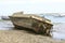 Old dirty and muddy boat on the sandy beach