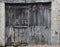 Old, dirty and weathered closed wooden barn door