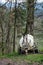 Old dirty white agricultural plastic tank for water or artificial fertilizers parked in woodlands