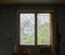 Old dirty window with tattered curtains in old abandoned building interior.