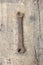 Old, dirty wrench against wooden plank.