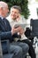 Old disabled woman and husband with digital tablet