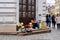 Old disabled woman sells flowers on the street corner