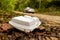 Old disposable plastic plate, box in the forest next to the road with car in a background.