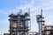 Old distillation column towers with blue sky with clouds background at chemical plant. Exterior of silver metal rusty