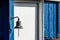 Old door bell in front of a blue wooden house