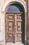 Old door with brown flaked paint with decorative ornaments