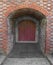 Old door at the end of a brick tunnel.