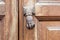 Old door knocker in shape of hand and wooden door background