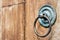 Old door ring handle on brown wooden door