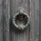 Old doorhandle on green wooden door