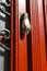 Old doorknocker with hand shape on red wooden door