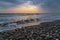 Old driftwood on seashore at sunrise