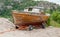 Old, dry, and forgotten wooden boat on a trolley