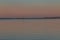 Old dry tree in the middle of the lake. Birds spend the night in the tree. There are dramatic clouds in the sky at sunset