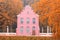 Old Dutch pink brick house with vintage fence in autumn