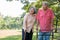 An old elderly Asian man uses a walker and walks in the park with his wife. Concept of happy retirement With Love and care from