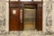 Old elevator with metal doors and wood grain paneling