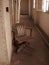 Old Empty Wooden Chair in Abandoned Hallway Sepia