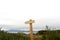 Old empty wooden pointer arrow in the middle of high dry grass and clear sky, selective focus