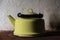 Old enameled kettle on the stove on a white background in dark colors.