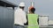 Old engineer and his assistance woman African ethnic analyzing the plan of construction on the rooftop of building