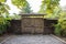 Old entrance gate made of wood with a road of stones or pavers