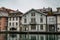 Old European Building on the Aare River in Thun Switzerland with Blue Water and Grey Sky.