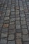 Old European courtyard, paved with gray cobblestones. Pavers texture. A perspective view of the monotonous gray brick