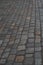 Old European courtyard, paved with gray cobblestones. Pavers texture. A perspective view of the monotonous gray brick