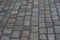 Old European courtyard, paved with gray cobblestones. Pavers texture. A perspective view of the monotonous gray brick