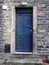 Old faded blue door with stone door frame