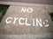 An old and faded sign printed on the floor saying no cycling