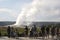 Old Faithful Geyser as seen with the crowd from the benches around the geyser Yellowstone