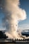 Old Faithful, Yellowstone exploding hot smoke before eruption in morning