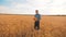 Old farmer man baker holds a golden bread and loaf in wheat field against the blue sky. slow motion video. successful