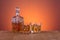 Old fashion glass and carafe with whisky drink on warm, orange background and wood