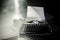 Old fashion typewritter on dark foggy background. Close up of vintage typewritter machine