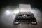 Old fashion typewritter on dark foggy background. Close up of vintage typewritter machine