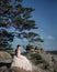 Old-fashioned bride sits on the rocks