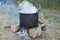 Old fashioned cooking stove with metal steel pans on a fire. Cooking food by scout at camping scout . the water evaporates from