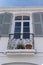 Old fashioned European little town apartment building with flowers on a small balcony