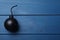 Old fashioned fuse bomb on blue wooden table, top view. Space for text